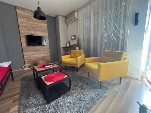 Sala de estar con 2 sillas amarillas y mesa en Bubinga, en Kruševac