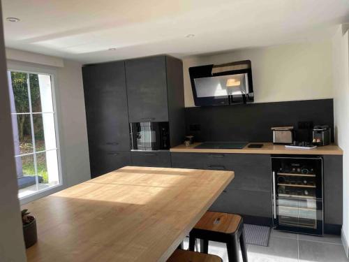 une cuisine avec une table en bois et un micro-ondes dans l'établissement Jolie petit F2 dans maison, à Beaugency