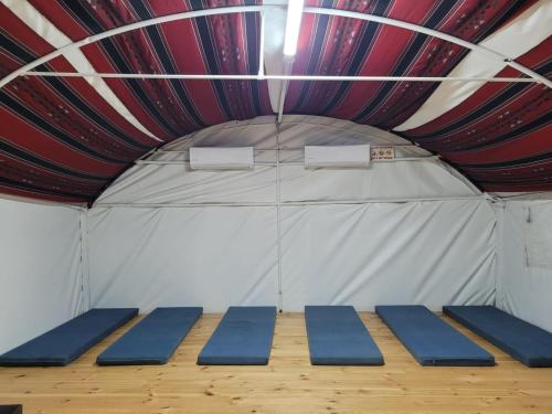 une scène avec des tapis bleus dans une tente dans l'établissement חאן דרך העץ - אוהל ממוזג וקמפינג, à Shadmot Devora