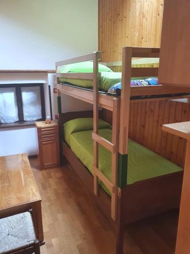 two bunk beds in a room with a table at AL CASTAGNO in Ponte Caffaro