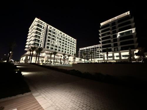 Address Beach Resort Residence في المنامة: إضاءة مبنيين طويلين في الليل