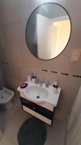 Un baño con lavabo, espejo e inodoro. en Apartamento Brisas del Mar, en Santa Clara del Mar