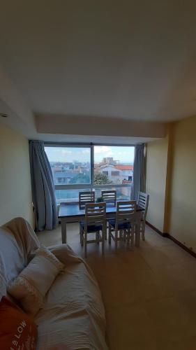 Una sala de estar con una mesa y sillas y una gran ventana. en Apartamento Brisas del Mar, en Santa Clara del Mar