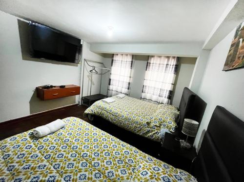 - une chambre avec 2 lits et une télévision à écran plat dans l'établissement JANAQ TERMINAL, à Cusco