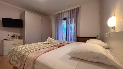 una camera da letto con un grande letto bianco e una finestra di Apartments Marija a Novigrad Istria