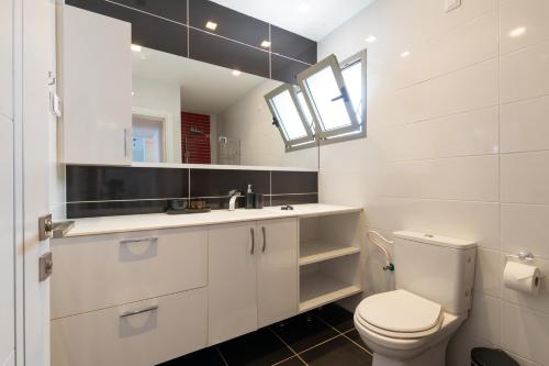 biała łazienka z toaletą i umywalką w obiekcie O&O Group - Luxury Tower/parking/Shopping Mall/2BR w mieście Qiryat Ono