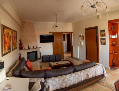 uma sala de estar com um sofá e uma lareira em Katy's apartment em Patra