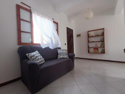 sala de estar con sofá y ventana en Vilas na areia aparthotel en Sal Rei