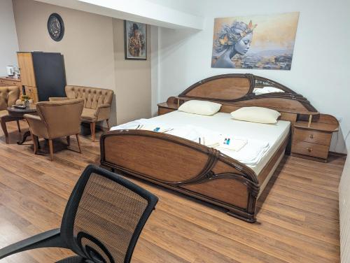 um quarto com uma cama grande, uma mesa e cadeiras em Apartments Victory em Kavadarci
