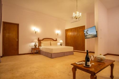 a large bedroom with a bed and a table at Samsara in Galle