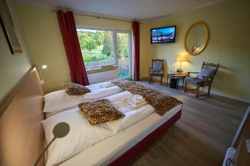 a bedroom with two beds with leopard pillows on them at Limburger MiKa Zimmer & Garten & E-Ladestation in Limburg an der Lahn