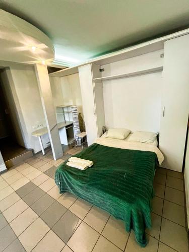 - une chambre avec un lit doté d'une couverture verte dans l'établissement Studio Bucuresti, à Chişinău