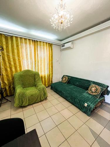 Cette chambre dispose d'un lit et d'une chaise verts. dans l'établissement Studio Bucuresti, à Chişinău