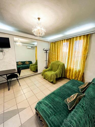 - une chambre avec un lit vert et un miroir dans l'établissement Studio Bucuresti, à Chişinău