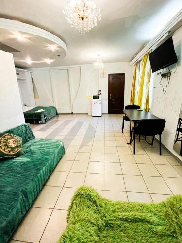 - un salon avec un canapé vert et une table dans l'établissement Studio Bucuresti, à Chişinău