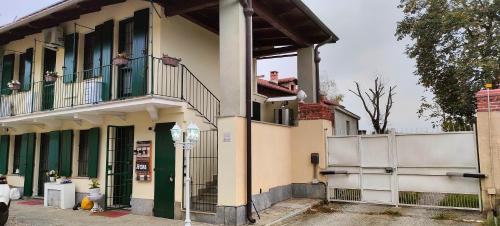 a white building with a balcony and a fence at Cascina Della Rocca in Caselle Torinese