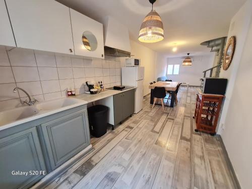 une cuisine avec un évier et une table à l'intérieur dans l'établissement T3 Duplex Quartier des artistes., à Sète