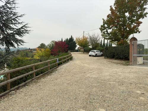 a white car parked in a driveway next to a fence at Agriturismo Bricco San Giovanni in Isola d'Asti