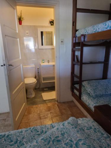 a bedroom with a bunk bed and a bathroom with a toilet at Apartamento con Terraza y Parrillero in Piriápolis