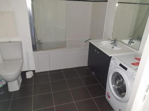 een badkamer met een toilet en een wasmachine bij Appartement idéal JO / Ideal apartment rental for the Olympic Games! in Saint-Denis