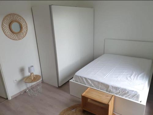 een kleine slaapkamer met een bed en een kleine tafel bij Appartement idéal JO / Ideal apartment rental for the Olympic Games! in Saint-Denis