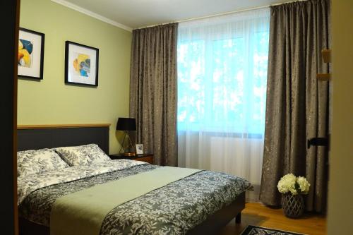 um quarto com uma cama e uma janela com cortinas em Cozy 2 Rooms Apartment Drumul Taberei em Bucareste