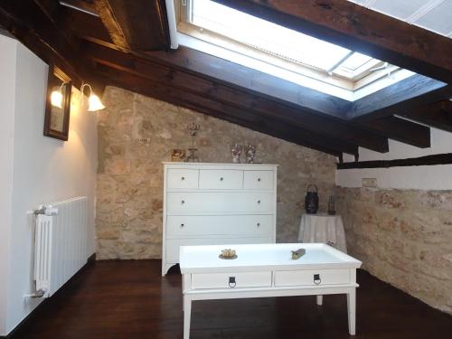 a bedroom with a white dresser and a skylight at LA CASONA DE ESCALADA in Escalada