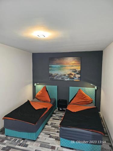 een slaapkamer met 2 bedden en oranje kussens bij Apartment am Stadion in Osnabrück