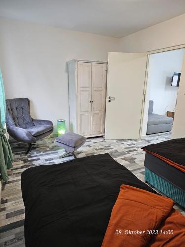 een slaapkamer met 2 stoelen en een bed in een kamer bij Apartment am Stadion in Osnabrück