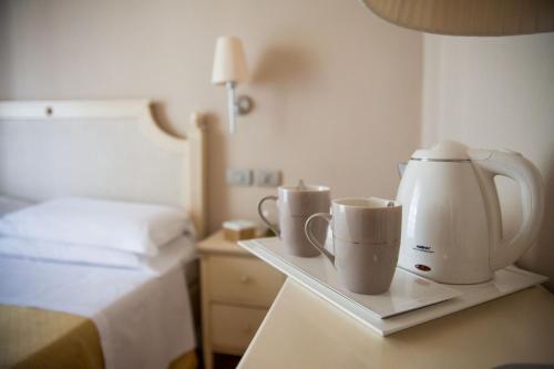 a hotel room with a coffee maker and two cups at Hotel Dei Fiori Restaurant - Meeting & Spa in Alassio