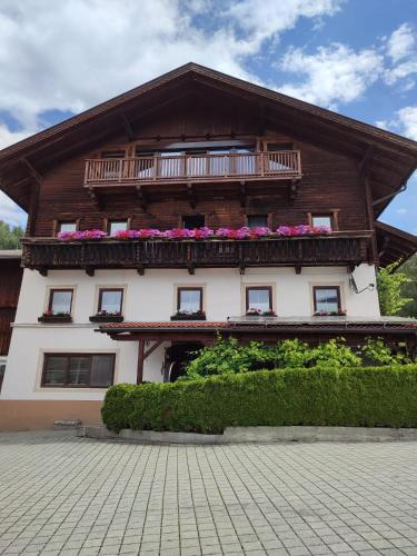 ein Gebäude mit einem Balkon und Blumen darauf in der Unterkunft Ferienwohnung Buchacher in Dölsach