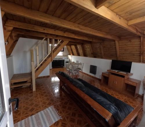 ein großes Wohnzimmer mit einem Sofa und einem TV in der Unterkunft Cabañas alpinas alumine in Perito Moreno