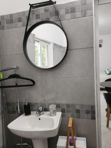a bathroom with a sink and a mirror on the wall at Résidence DENGUELE Studio in Saint-Laurent du Maroni