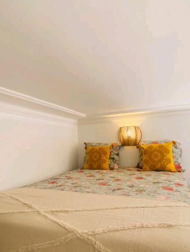 - une petite chambre avec un lit et des oreillers jaunes dans l'établissement La Parenthèse Enchantée - Belfort Centre proche gare - Fibre Netflix, à Belfort