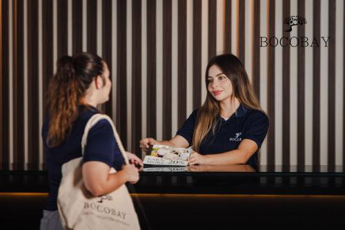 two women sitting at a table with a cake at O Condominium Beachfront Residences, by Bocobay Aruba in Palm-Eagle Beach