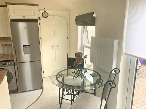 a kitchen with a glass table and a refrigerator at Naas 2 Bedroom Back Garden Escape in Naas