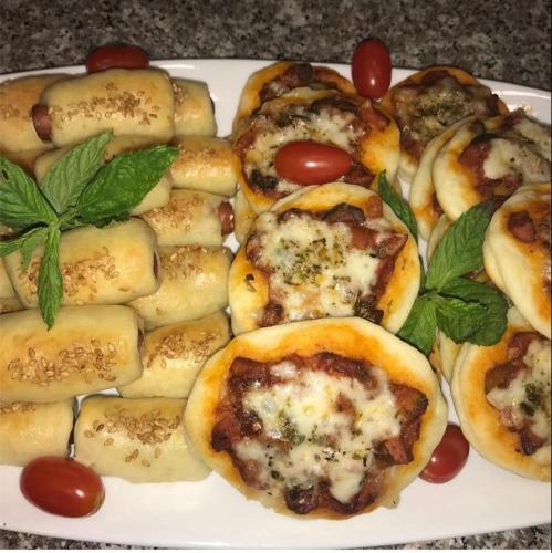 a plate of mini pizzas with tomatoes and basil at Little Green Farm in Wadi Musa