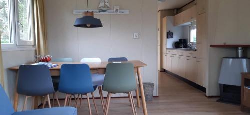 een keuken met een houten tafel en blauwe stoelen bij Chalet Wad Mooi in Buren