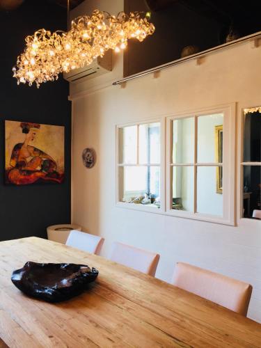 une salle à manger avec une table en bois et un lustre dans l'établissement les Arcenaulx de Marianne, à Marseille