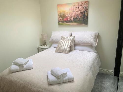 a bedroom with a white bed with towels on it at Naas 2 Bedroom Back Garden Escape in Naas