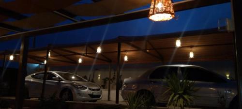 two cars parked in a parking lot at night at Little Green Farm in Wadi Musa