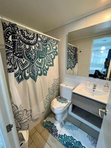 een badkamer met een toilet, een wastafel en een spiegel bij Acogedor home studio in Santiago