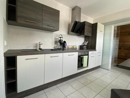 a kitchen with white cabinets and a sink at An den Bergwiesen in Winterberg