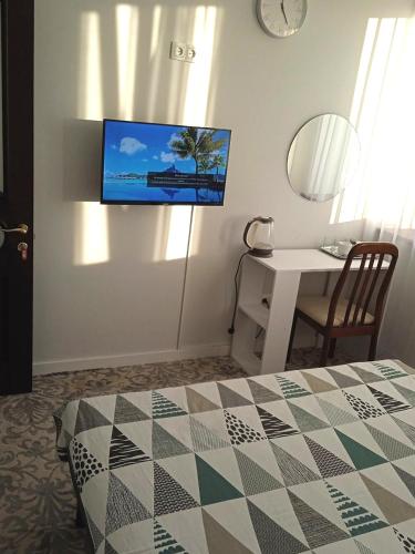 a bedroom with a bed and a table and a tv on the wall at Приватний будинок в Миколаєві з гаражем Private House in Mykolaiv with garage in Mykolaiv