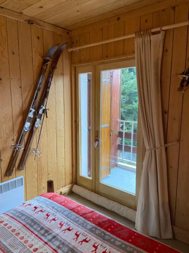 BEL APPARTEMENT MONTAGNE AVEC VUE في أورسيير: غرفة نوم مع نافذة وسرير في غرفة