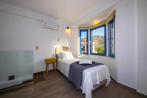 Habitación blanca con cama y ventana en NJV plus K en Aegina Town