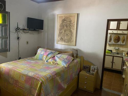 1 dormitorio con 1 cama y TV en la pared en Casa ampla de frente ao mar en Cacha Pregos
