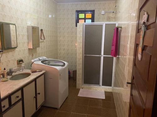 een badkamer met een wasmachine en een wastafel bij Casa ampla de frente ao mar in Cacha Pregos