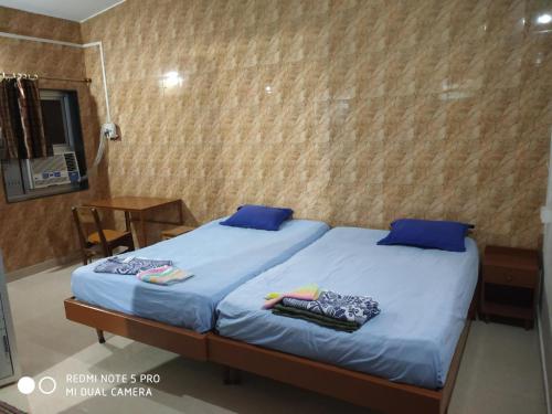 a bedroom with a bed with blue sheets and blue pillows at Bethel Guesthouse Panaji in Panaji