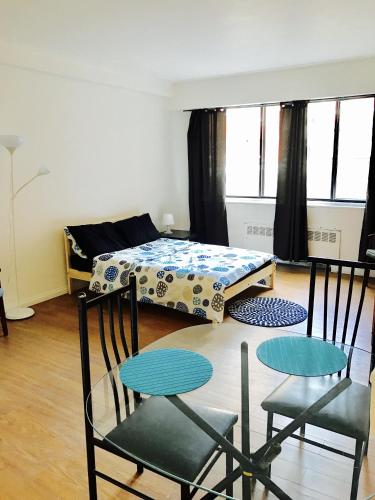 Habitación con 2 sillas, mesa y cama en Stylish Montreal Apartment: Comfortable Stay in the Golden Square Mile, en Montreal